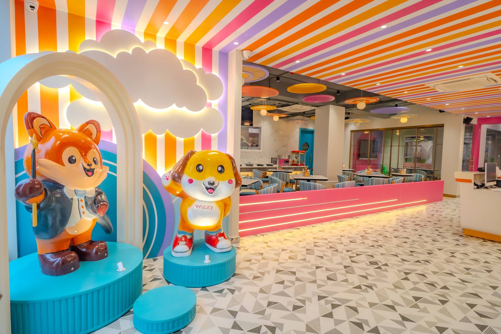 Whimsi and Wizzy mascot statues at the WhimsiLand entrance, with Wizzy Café behind