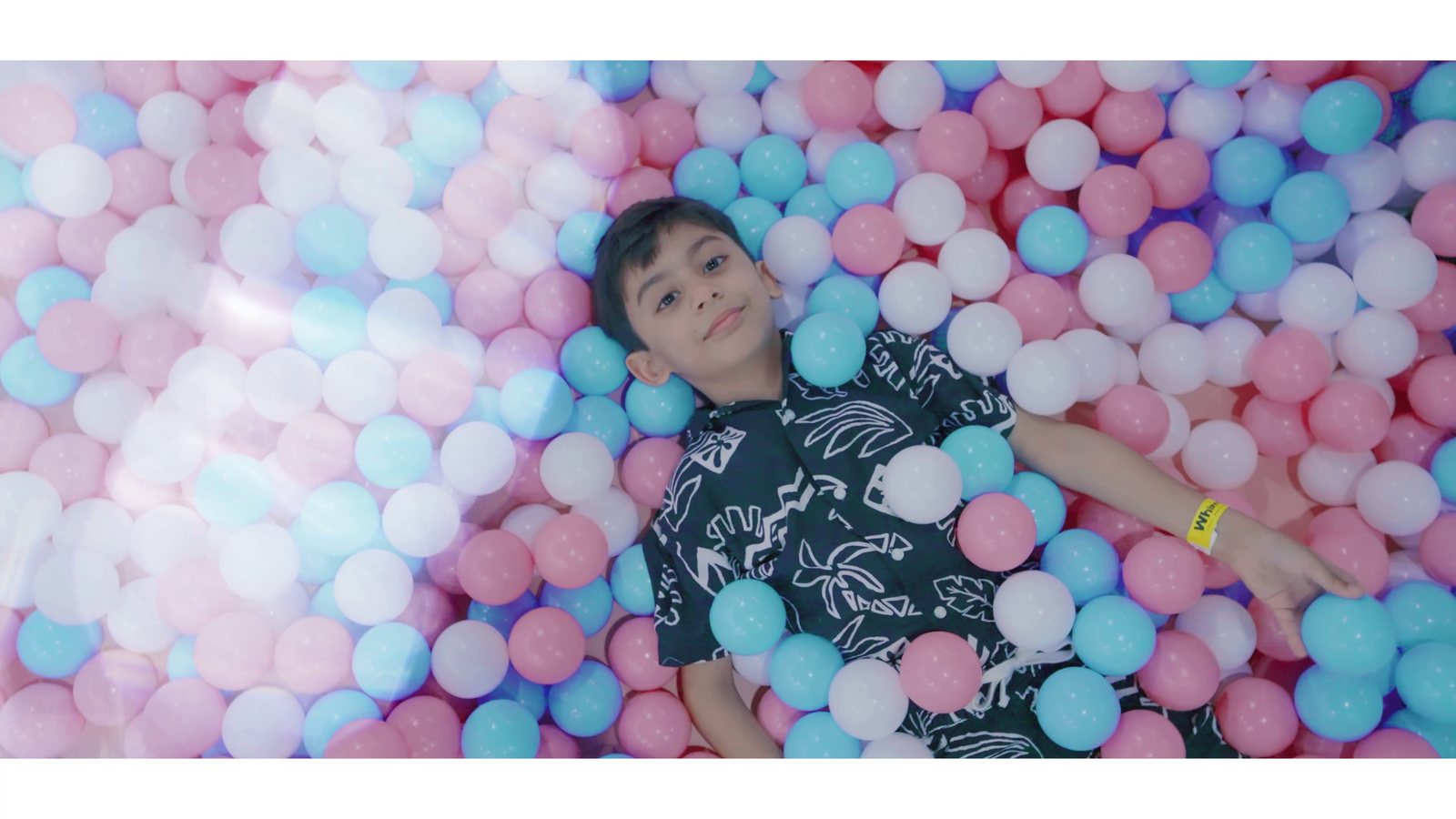 A child lying happily in the WhimsiLand ball pit