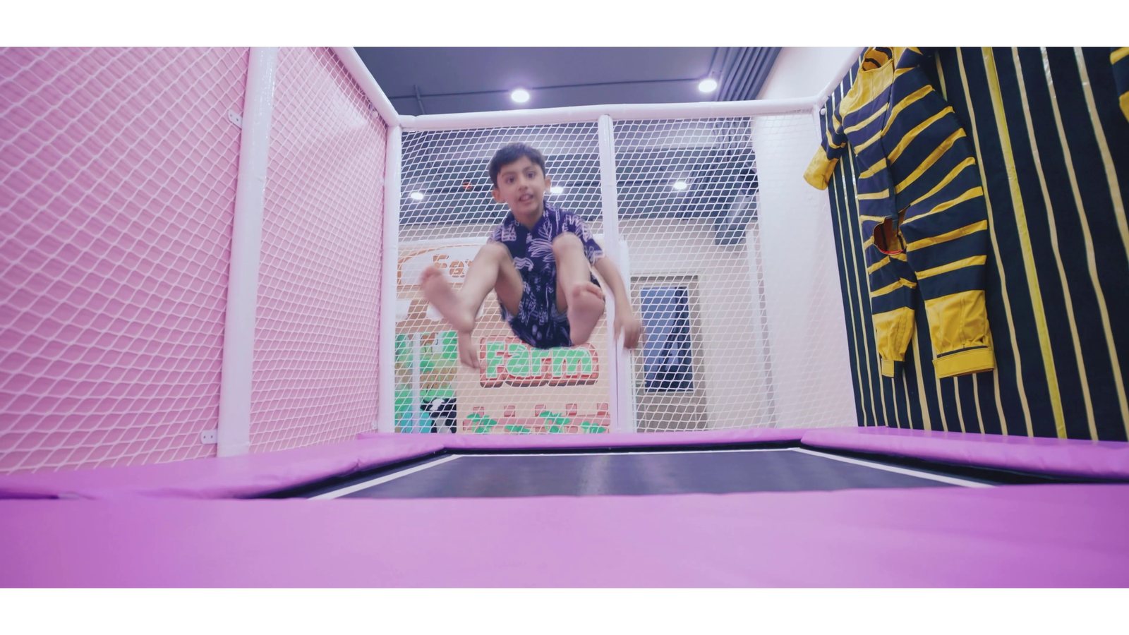 A child mid-air on the trampolines, velcro wall behind