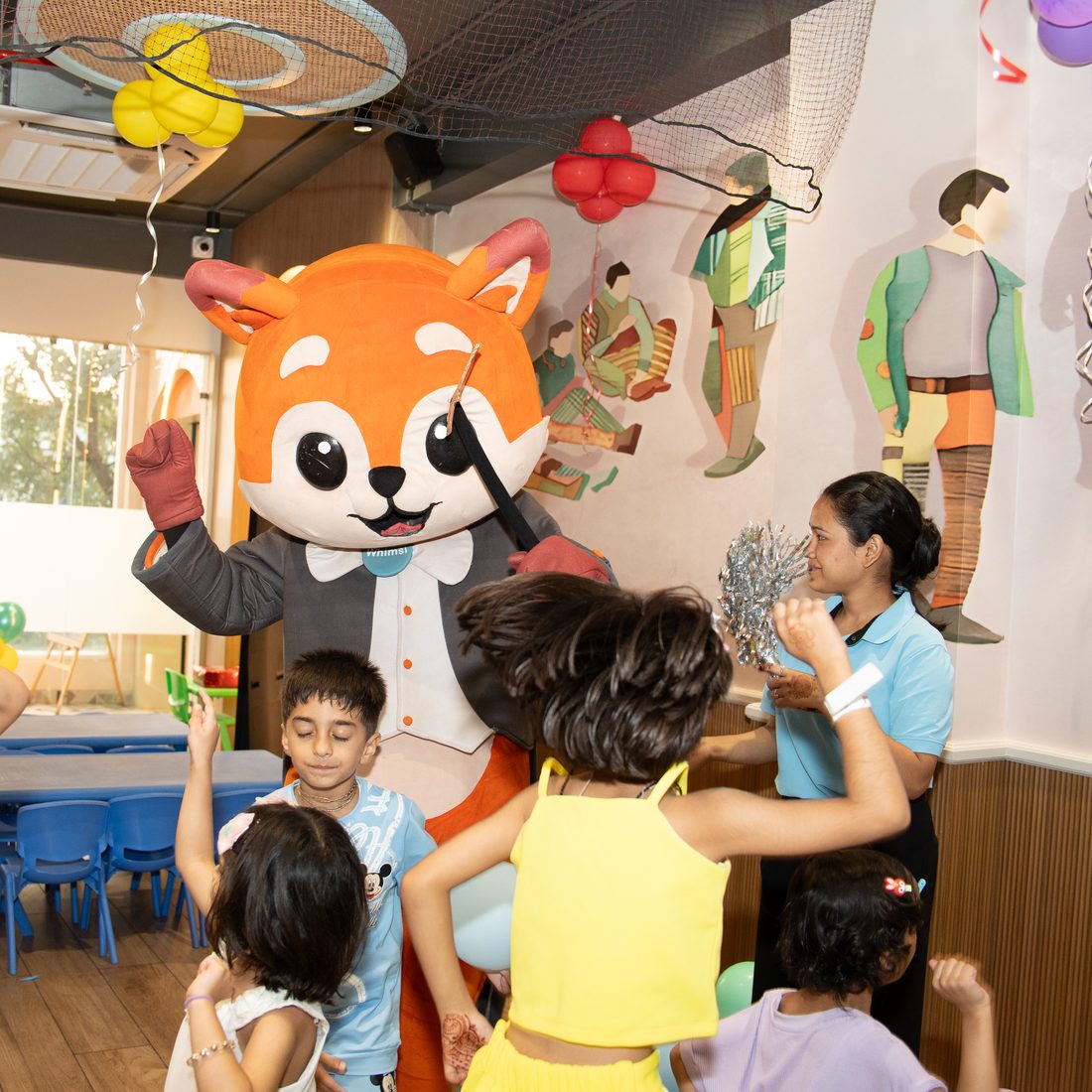 Whimsi leading the party games with a host and a group of children
