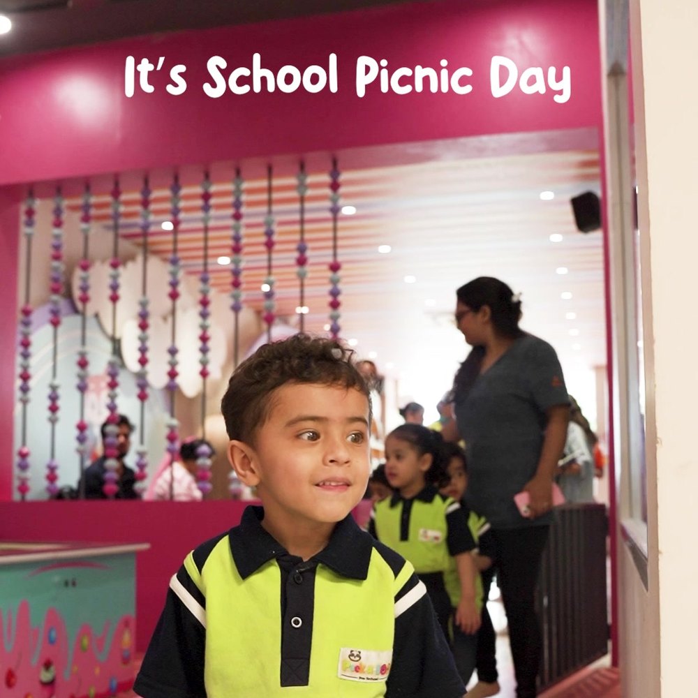 A child arriving past the It's School Picnic Day sign at WhimsiLand