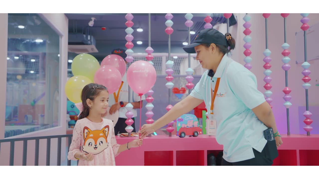 Staff handing a balloon to a child at WhimsiLand